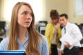 Businesswoman Being Gossiped About By Colleagues In Office