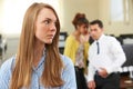 Businesswoman Being Gossiped About By Colleagues In Office