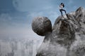 Businesswoman with big rock on the cliff Royalty Free Stock Photo