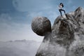 Businesswoman with big rock on the mountain Royalty Free Stock Photo