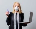 Businesswoman in black suit and face mask with money and computer