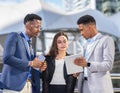 businesswoman in black suit working with black executive man in blue suit and businessman in grey suit.