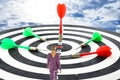 Businesswoman on board with color darts hitting target against cloudy sky Royalty Free Stock Photo