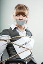Businesswoman bound by contract with taped mouth.