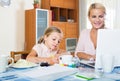 Businesswoman browsing internet at home, daughter drawing in p Royalty Free Stock Photo