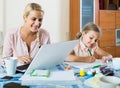 Businesswoman browsing internet at home, daughter drawing in p Royalty Free Stock Photo