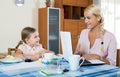 Businesswoman browsing internet at home, daughter drawing in p Royalty Free Stock Photo