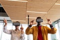 Businesswoman and businessman in casuals gesturing while using virtual reality headsets in office Royalty Free Stock Photo