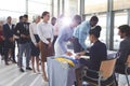 Businesswoman and businessman signing in at conference registration table Royalty Free Stock Photo