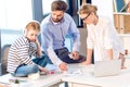 Businesswoman and businessman working with documents and laptop while daughter sitting with headphones Royalty Free Stock Photo