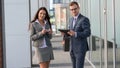 Businesswoman and businessman working outside with mobile phone and tablet pc. Royalty Free Stock Photo