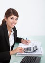 Businesswoman calculating bills at desk Royalty Free Stock Photo