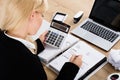 Businesswoman Calculating Invoice In Office Royalty Free Stock Photo