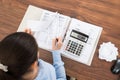 Businesswoman calculating tax at desk