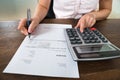 Businesswoman Calculating Tax At Desk