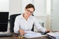 Businesswoman Calculating Tax At Desk Royalty Free Stock Photo