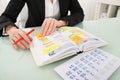 Businesswoman With Calendar Writing Schedule In Diary