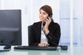 Businesswoman on call while using computer at desk Royalty Free Stock Photo