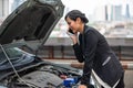 A businesswoman is calling for help as her car breaks down on the side of the road Royalty Free Stock Photo