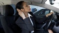 Businesswoman in car looking in rear-view mirror, overconfidence, narcissism