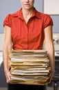 Businesswoman carrying stack of file folders