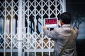 Businesswoman closing her business activity due economy crisis putting closed sign on the door of his store. Concept of bankrupt Royalty Free Stock Photo