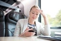 Businesswoman communicating on mobile phone while traveling by train.