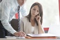 Businesswoman concentrating while colleague explaining at desk