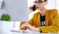 Businesswoman concentrating on work, using computer and cellphone in office Royalty Free Stock Photo