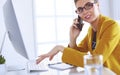 Businesswoman concentrating on work, using computer and cellphone in office Royalty Free Stock Photo