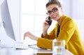 Businesswoman concentrating on work, using computer and cellphone in office Royalty Free Stock Photo