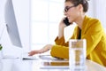 Businesswoman concentrating on work, using computer and cellphone in office Royalty Free Stock Photo