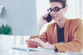 Businesswoman concentrating on work, using computer and cellphone in office Royalty Free Stock Photo