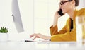 Businesswoman concentrating on work, using computer and cellphone in office Royalty Free Stock Photo