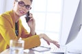 Businesswoman concentrating on work, using computer and cellphone in office Royalty Free Stock Photo