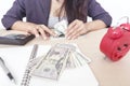 Businesswoman counting money on table.