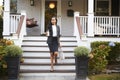 Businesswoman With Cup Of Coffee Leaving Suburban House For Work