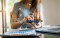 Businesswoman or Designer using mobile phone with laptop and digital tablet laptop and document on desk in office Royalty Free Stock Photo