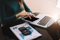 Businesswoman or Designer using tablet with laptop and document on desk. Royalty Free Stock Photo