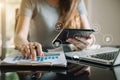 Businesswoman or Designer using tablet with laptop and document on desk in modern office. Royalty Free Stock Photo