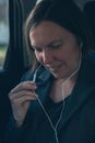 Businesswoman dictating into smartphone earphones microphone