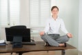 Businesswoman Doing Yoga In Office Royalty Free Stock Photo