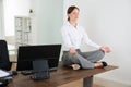 Businesswoman Doing Yoga In Office Royalty Free Stock Photo
