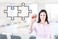 Businesswoman drawing a Blank Puzzle on the screen. Office background. Royalty Free Stock Photo