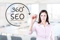 Businesswoman drawing a 360 degrees SEO concept on the virtual screen. Office background. Royalty Free Stock Photo