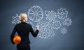 Businesswoman draws gears mechanism on blackboard Royalty Free Stock Photo