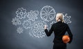 Businesswoman draws gears mechanism on blackboard Royalty Free Stock Photo