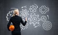 Businesswoman draws gears mechanism on blackboard Royalty Free Stock Photo