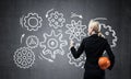 Businesswoman draws gears mechanism on blackboard Royalty Free Stock Photo