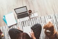 Businesswoman dressed in pajamas writing and enjoying morning coffee on the floor office with beagle dog with laptop, papers. Royalty Free Stock Photo